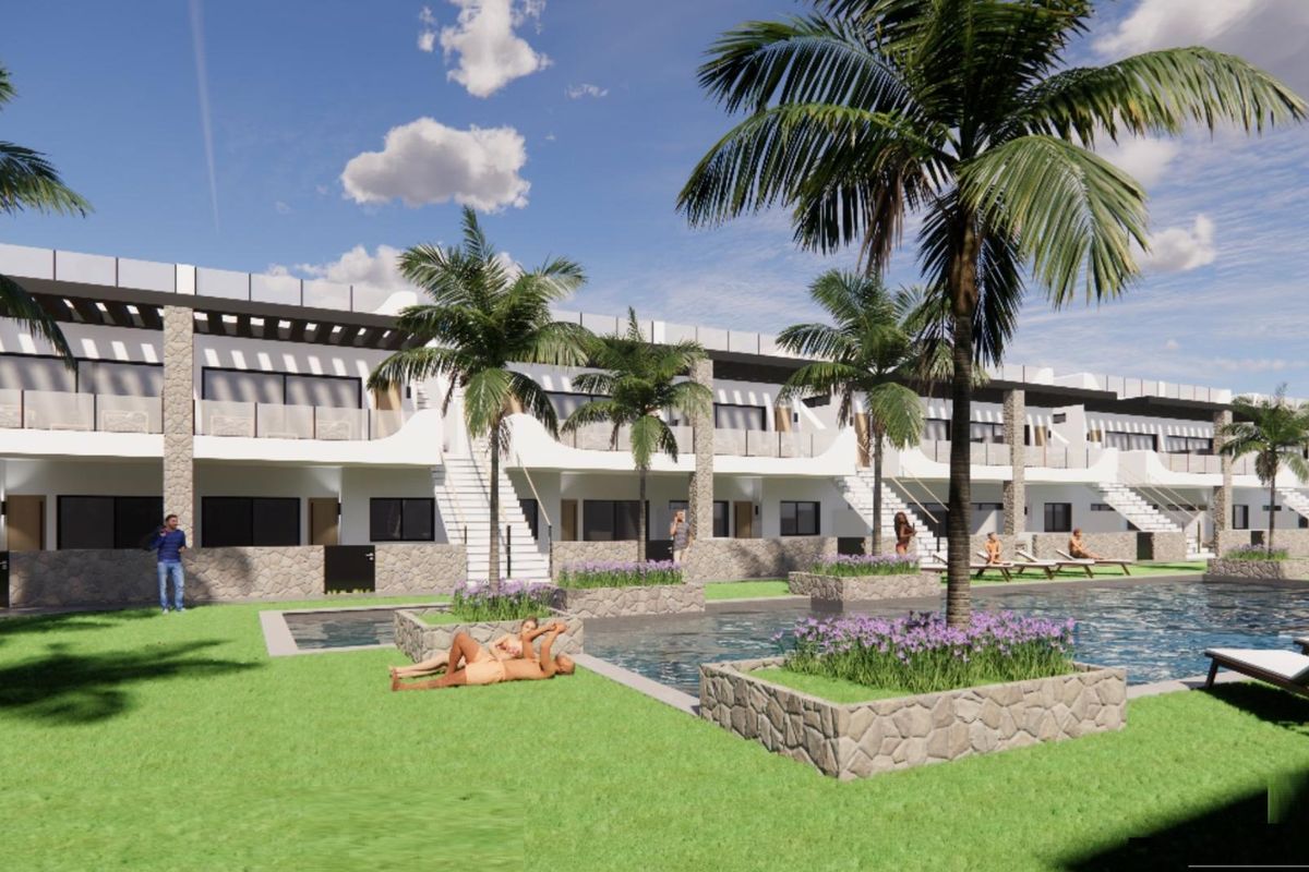 Buitenzicht op een wooncomplex in Torrevieja met een zwembad en palmbomen.