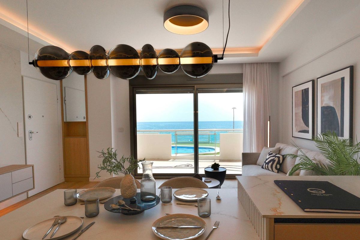 Elegant dining area with table settings, large windows, and sea views in La Manga del Mar Menor, Spain.