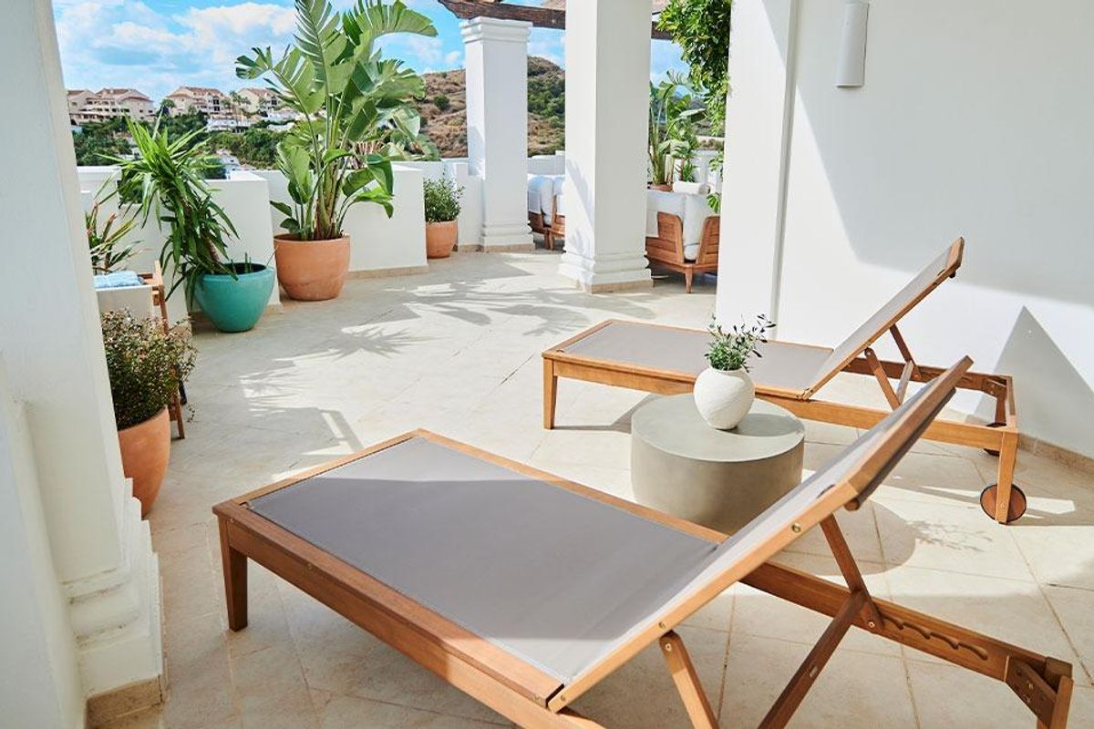 Ontspannende terrassruimte met ligstoelen en planten, met charmant uitzicht in Marbella, Spanje.