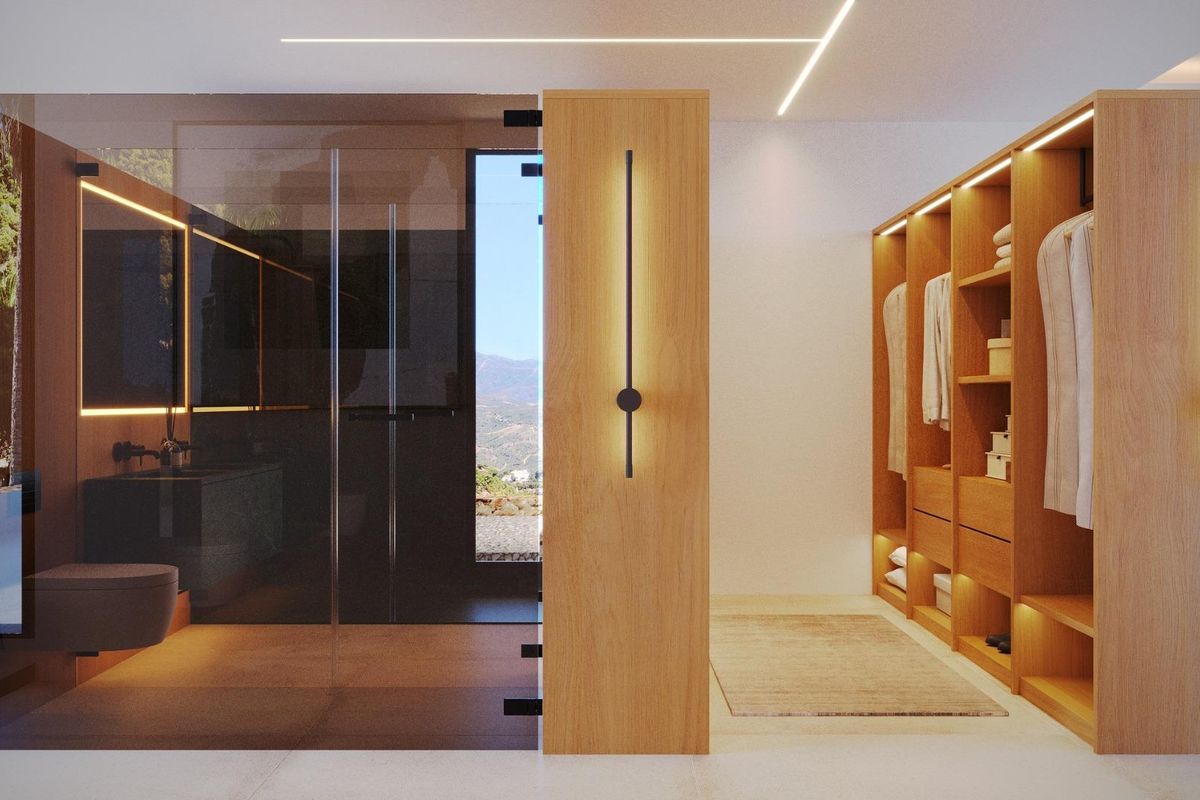 Ruimtelijk kleedkamer met houten planken en uitzicht op een luxe badkamer, van een 4-slaapkamer villa in Jávea, Costa Blanca Noord.