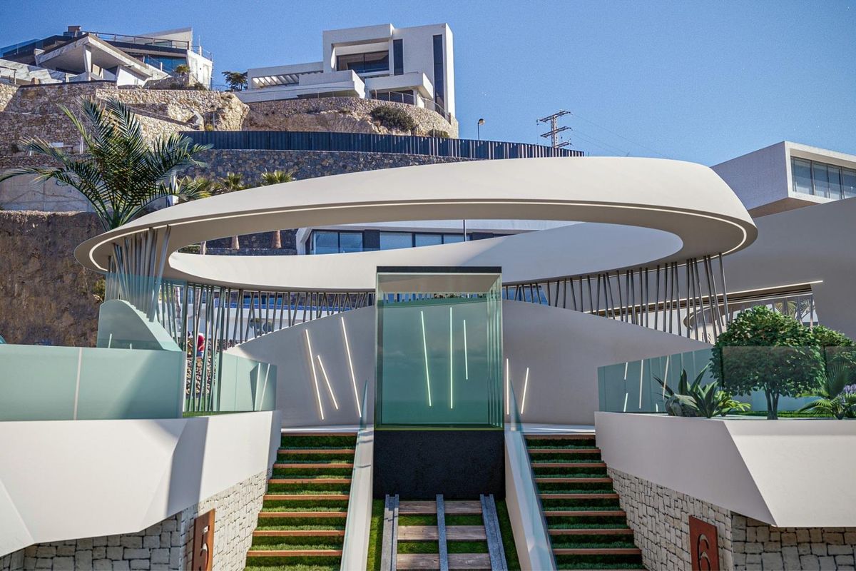 Buitenkant van een hedendaagse villa-ingang in Calpe, met stijlvol ontwerp en weelderig groen.