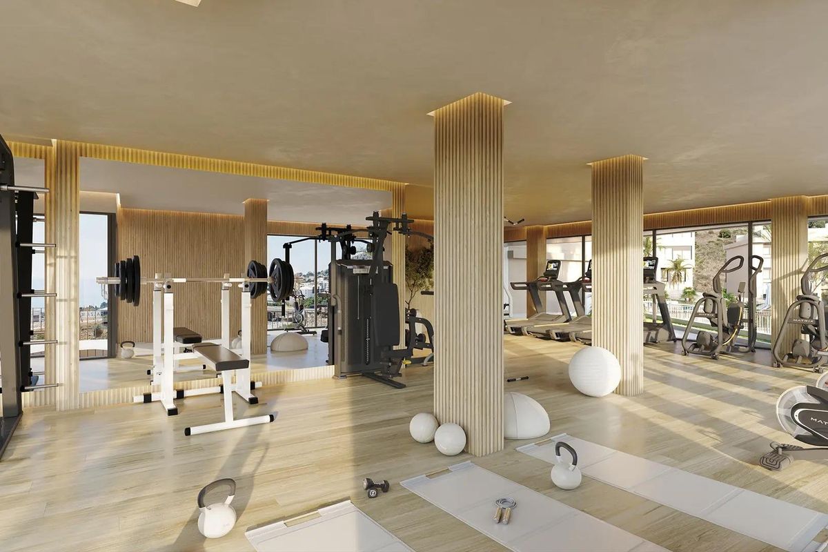 Moderne sportszaal met fitnessapparatuur en uitzicht, gelegen in een penthouse in Fuengirola, Costa del Sol.