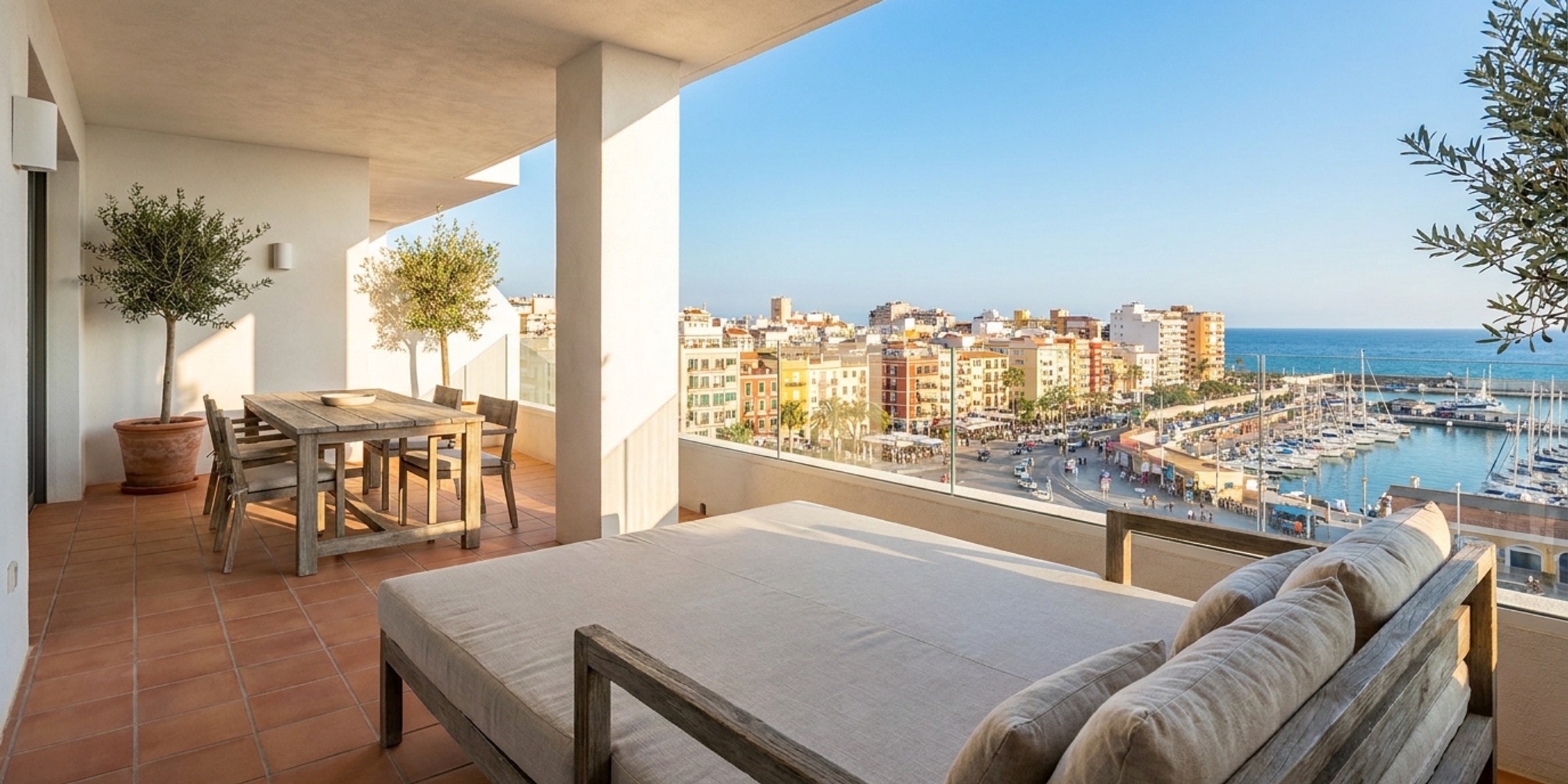 Bright and modern apartment balcony overlooking a vibrant Spanish coastal city
