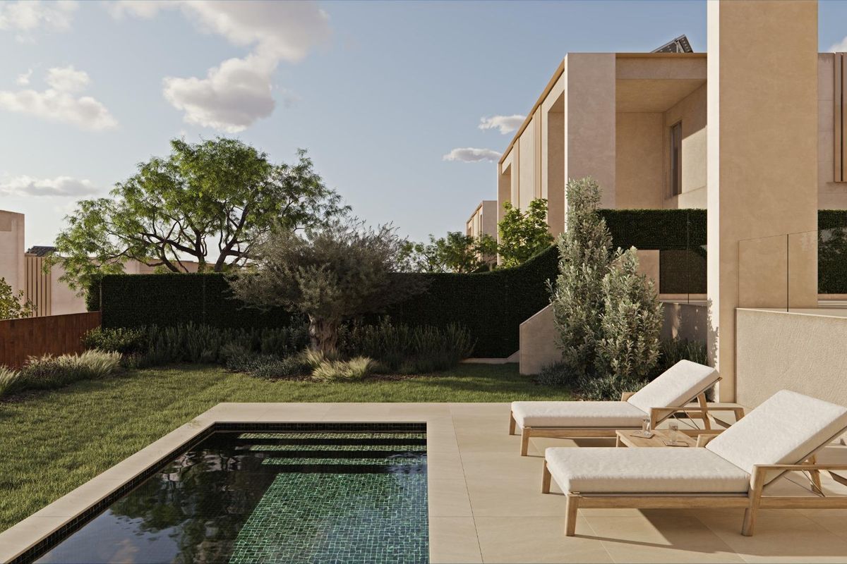 Zijaanzicht van de tuin van een rijtjeshuis in Godella, Costa Blanca North, met ligstoelen en aangelegde tuinen.