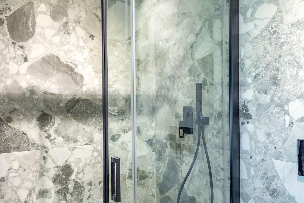 Close-up van een chique douchegedeelte met elegante marmer in een 2-slaapkamerappartement in Finestrat, Costa Blanca Noord.