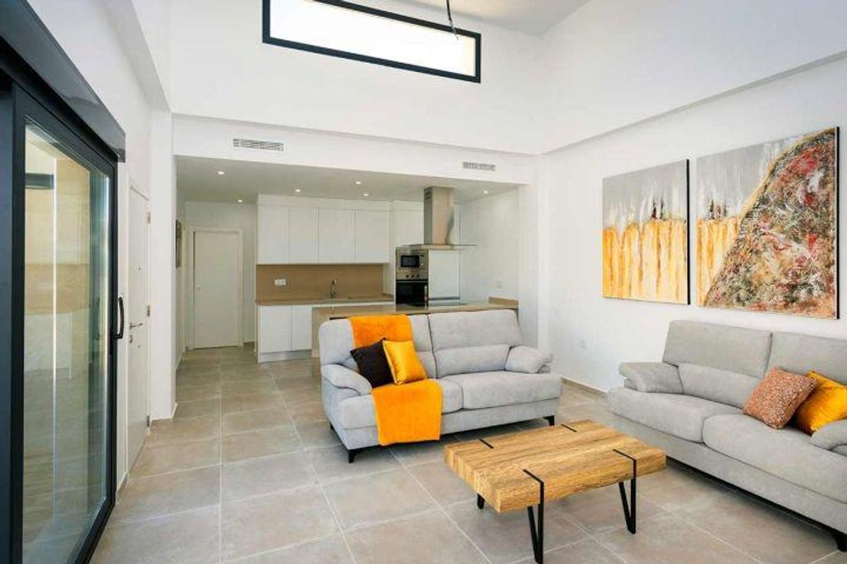Open woonruimte in een 3-slaapkamer bungalow in Daya Nueva, met een moderne keuken en gezellige zithoek.