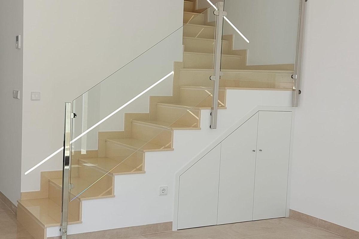 Stijlvolle trap met glazen leuning die verschillende niveaus verbindt in een villa in San Pedro del Pinatar.