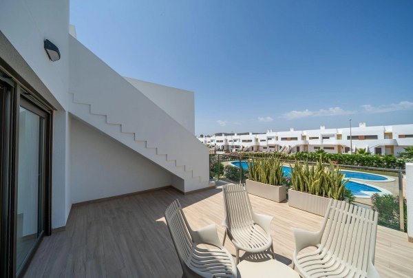 Stijlvol terras met zitplaatsen en uitzicht op het gemeenschappelijke zwembad in Orihuela, Costa Blanca Zuid, Spanje.