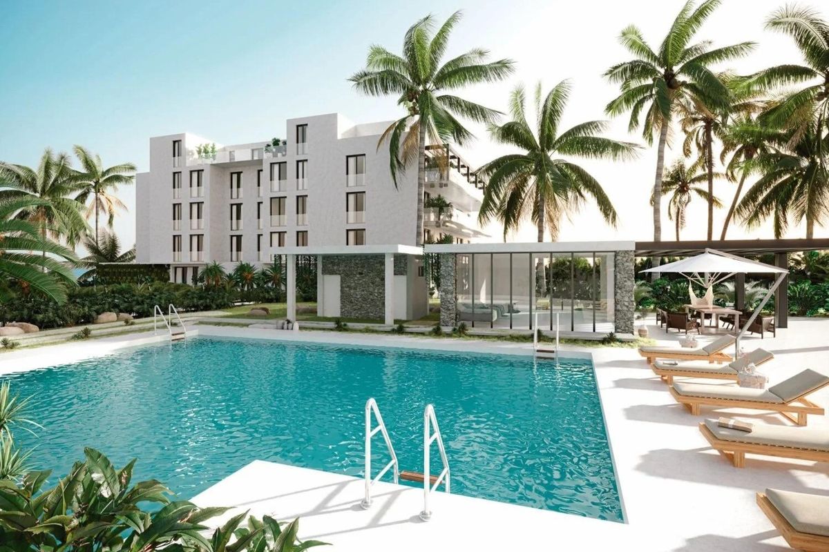 Serene zwembadgebied met ligstoelen en palmbomen, onderdeel van een modern complex in Mijas, Costa del Sol.