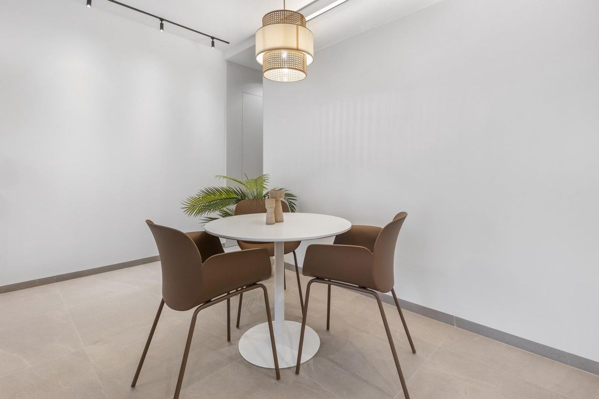 Eetruimte voor twee in een moderne appartement met een witte tafel en stijlvolle stoelen in Torrevieja.