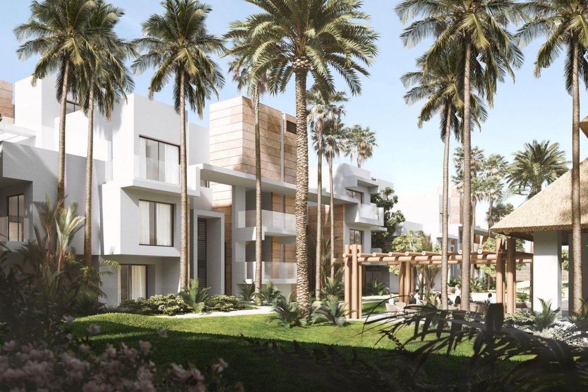 Buitenzicht op een modern 2-slaapkamer appartementcomplex omringd door palmbomen in Estepona, Costa del Sol.