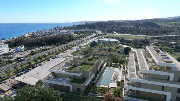 Luchtfoto van een modern appartementencomplex in Estepona, nabij de kust met een zwembad en tuinen.