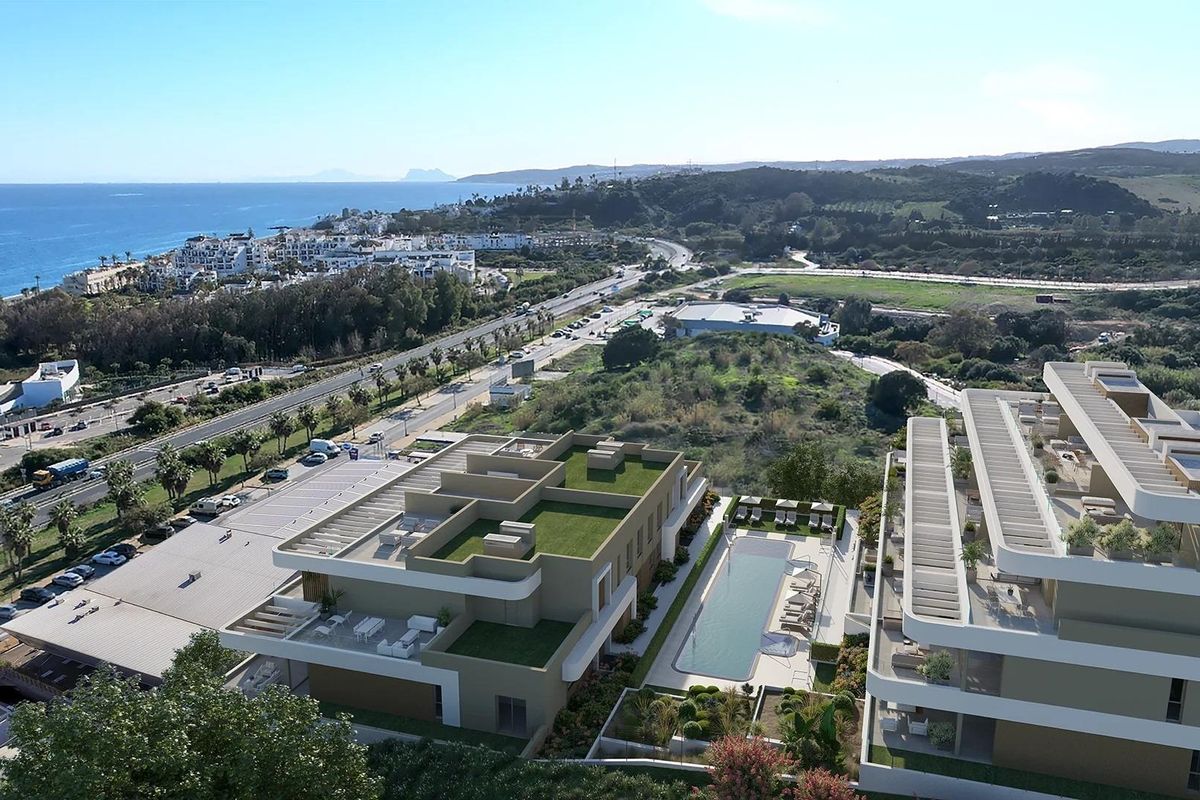 Luchtfoto van Estepona met moderne appartementen en de nabijgelegen kustlijn, inclusief een zwembadgebied.