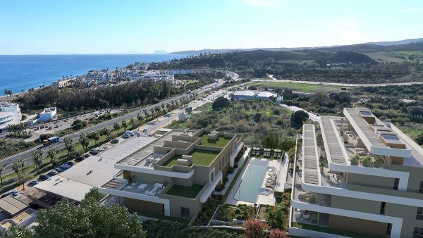 Luchtfoto van een modern appartementencomplex in Estepona, nabij de kust met een zwembad en tuinen.