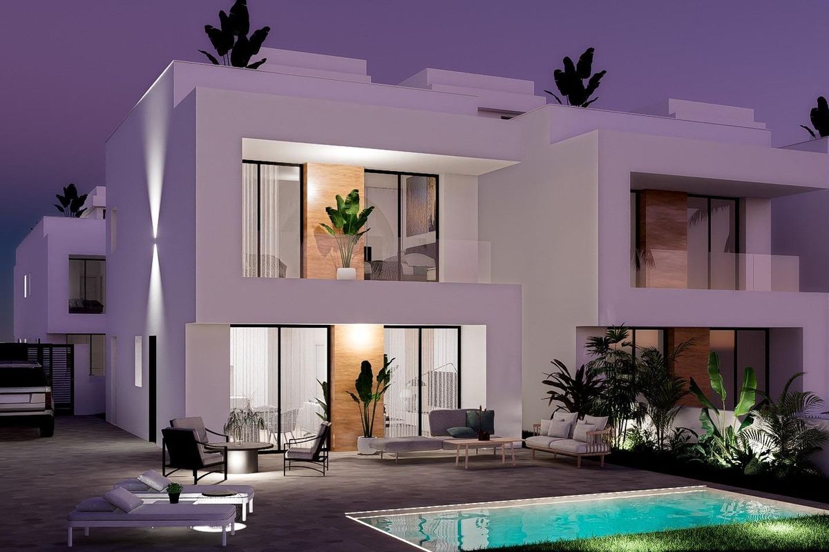 Nachtzicht op een hedendaagse townhouse met verlicht zwembad en moderne meubels in Orihuela Costa.