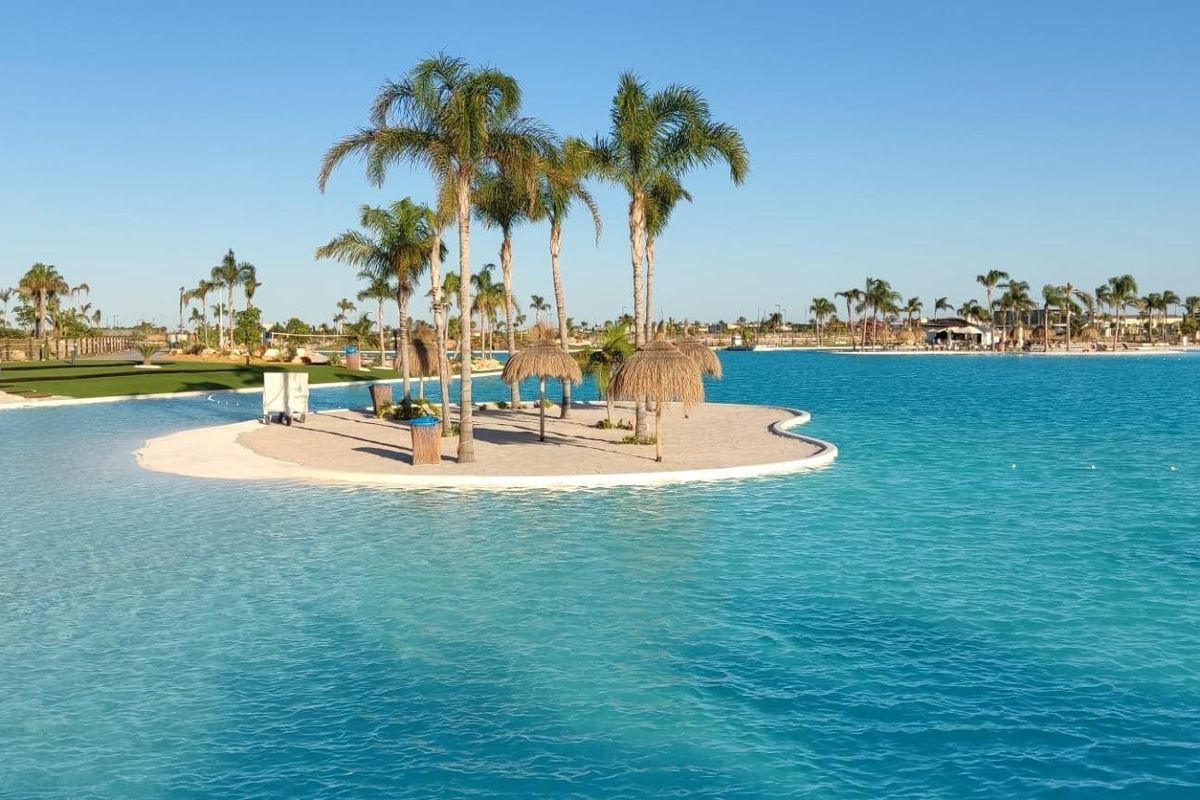 Pittoresk uitzicht op het water van een lagune-achtig zwembad met palmbomen in Torre Pacheco.