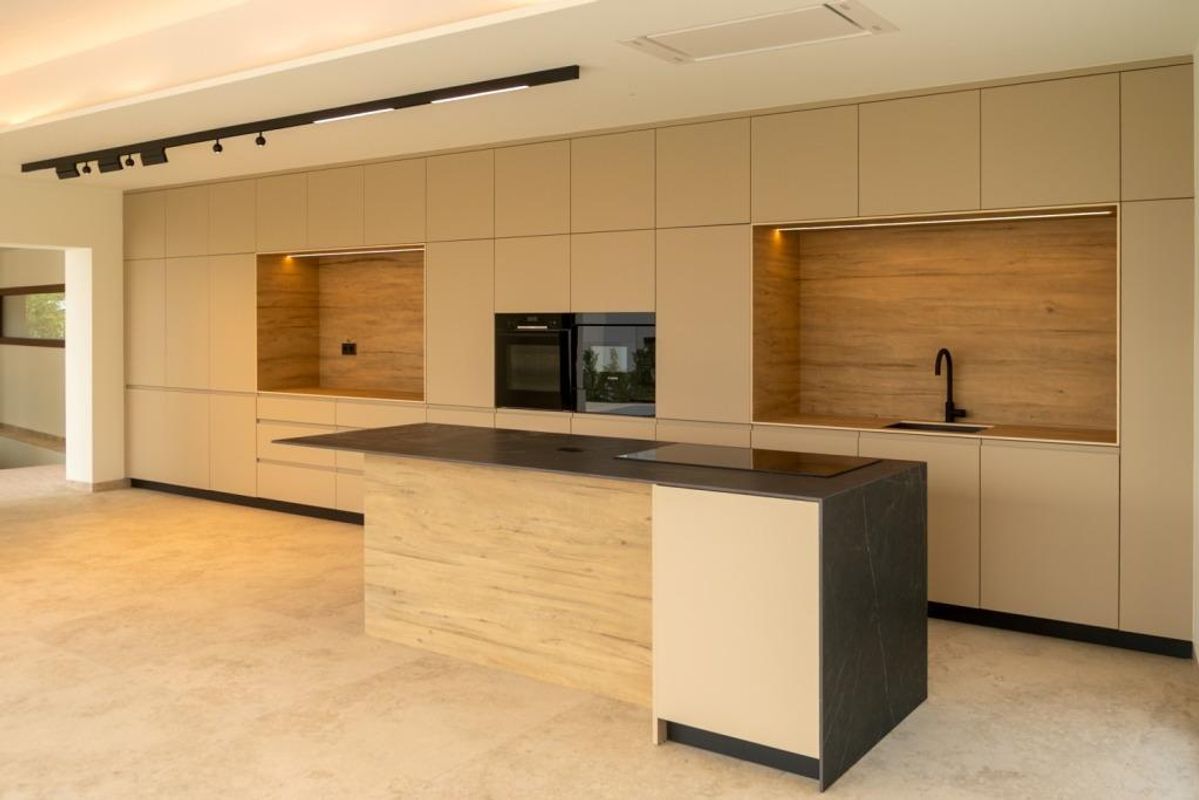 Modern ontwerp van de keuken met strakke kasten in het interieur van de villa.