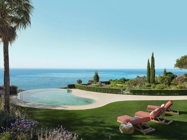 Indrukwekkend uitzicht op het infinity zwembad en de oceaan, weelderige tuin in Benalmádena, Costa del Sol.