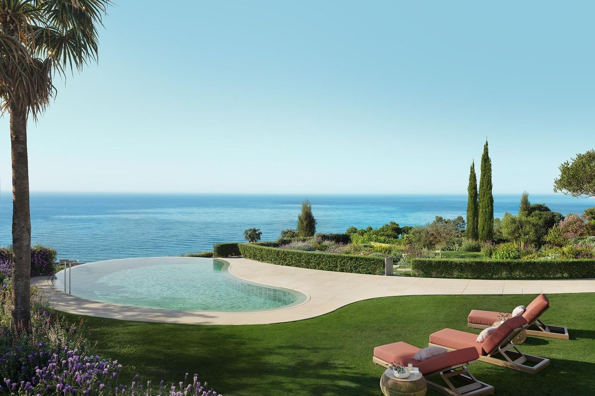 Ontspannende zwembadzone met ligstoelen en weelderige tuin met uitzicht op zee in Benalmádena, Costa del Sol.