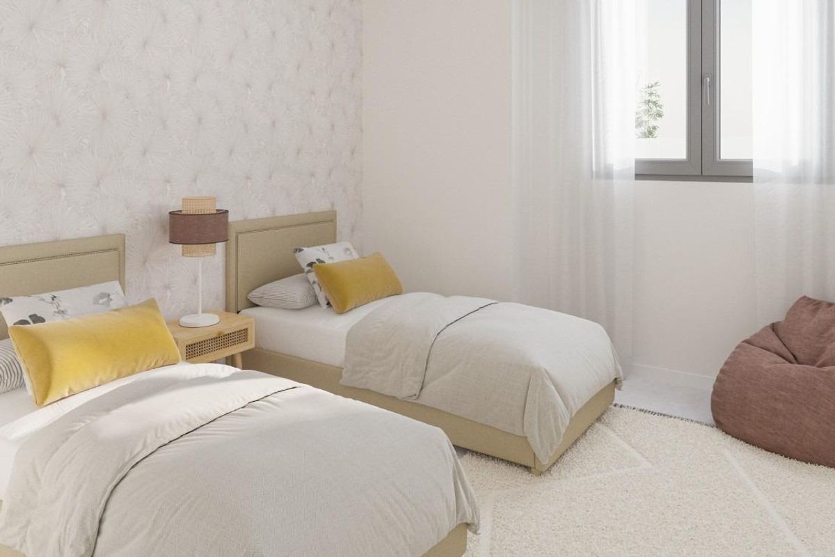 Stijlvolle kinderkamer met twee eenpersoonsbedden en zachte kleuren in een penthouse in Benalmádena.