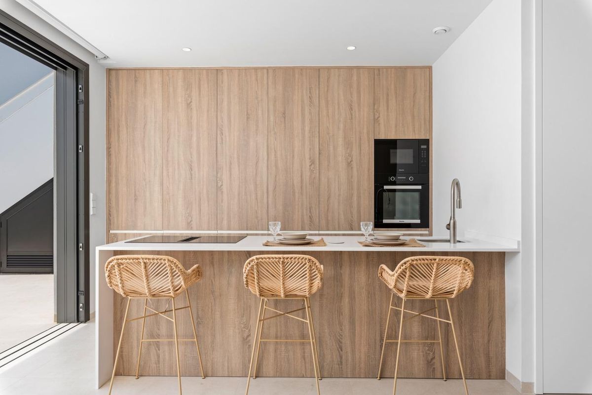 Moderne keukenruimte met een strak ontwerp en bar in een townhouse in Los Alcazares.