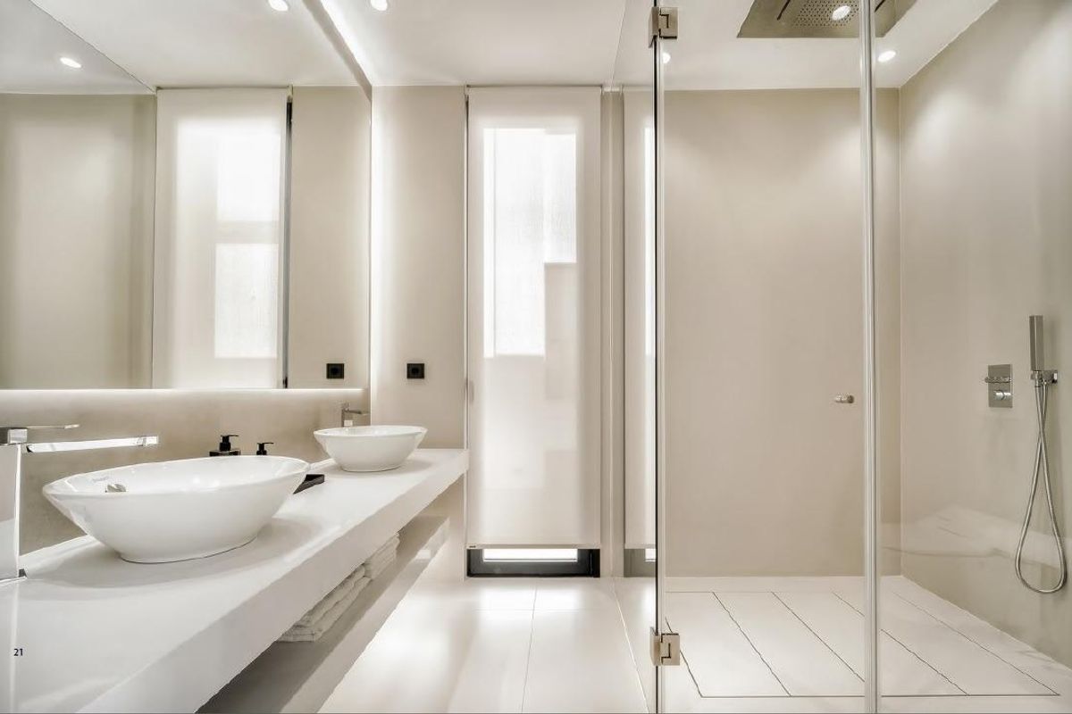 Strakke badkamer met moderne materialen en een glazen douche in een villa in Marbella.