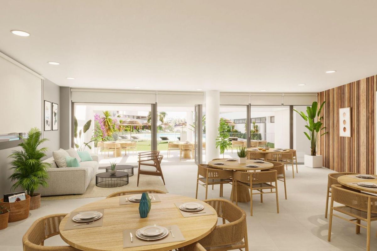 Heldere gemeenschappelijke eetruimte van het appartementencomplex met uitzicht op het zwembad in Estepona, Costa del Sol.