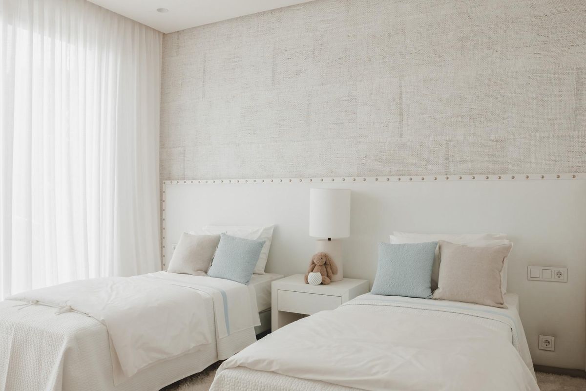 Luchtige badkamer met dubbele wastafels en ramen met uitzicht op de tuin in een appartement in Benahavís.