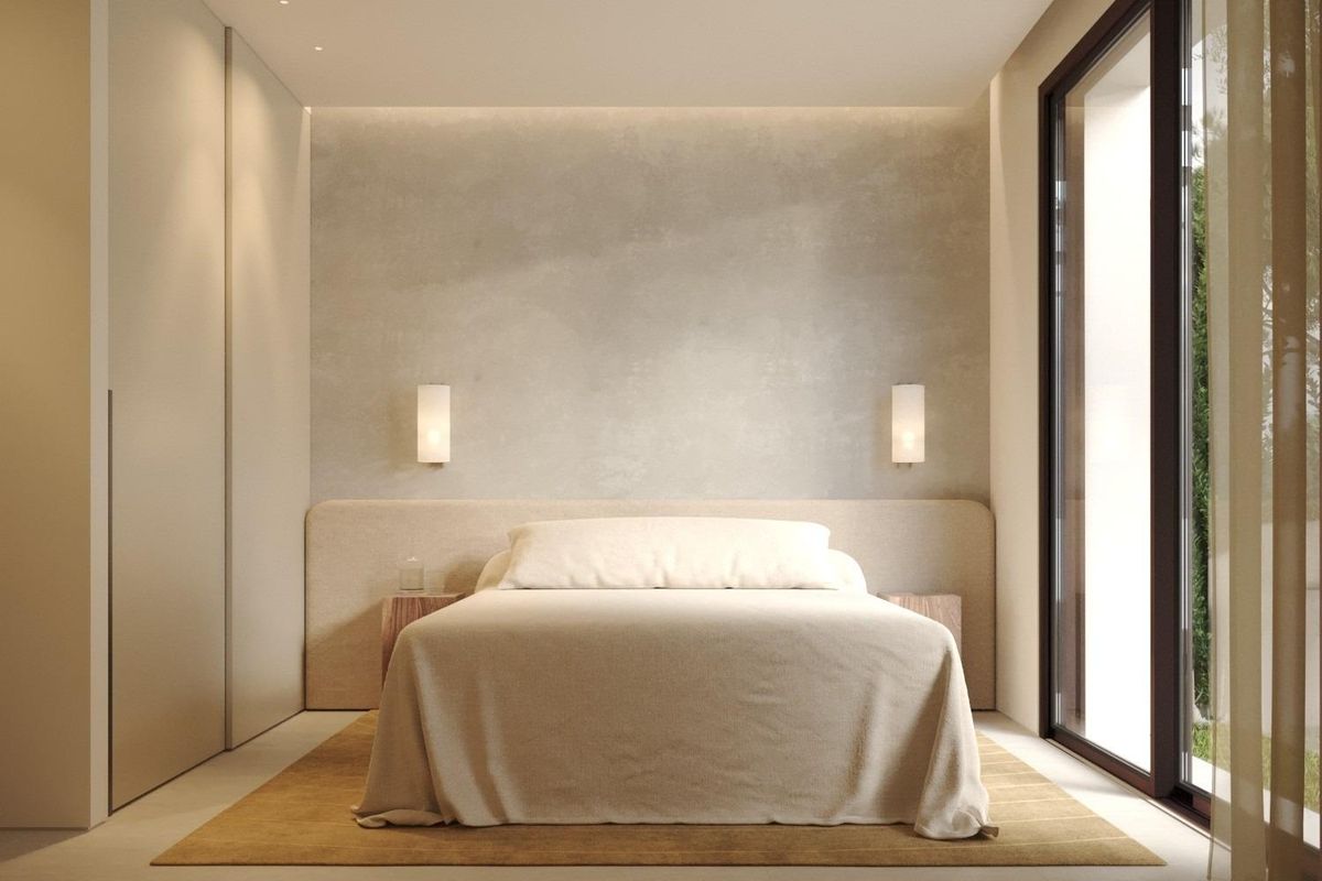 Minimalistische slaapkamer met neutrale bedekking, houten nachtkastjes, wandlampen en groot raam met uitzicht op groen in Dolores, Costa Blanca