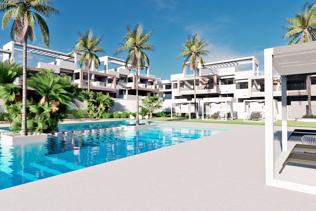 Zonovergoten bungalowcomplex in Finestrat met een zwembadgebied, omgeven door palmbomen en moderne architectuur.