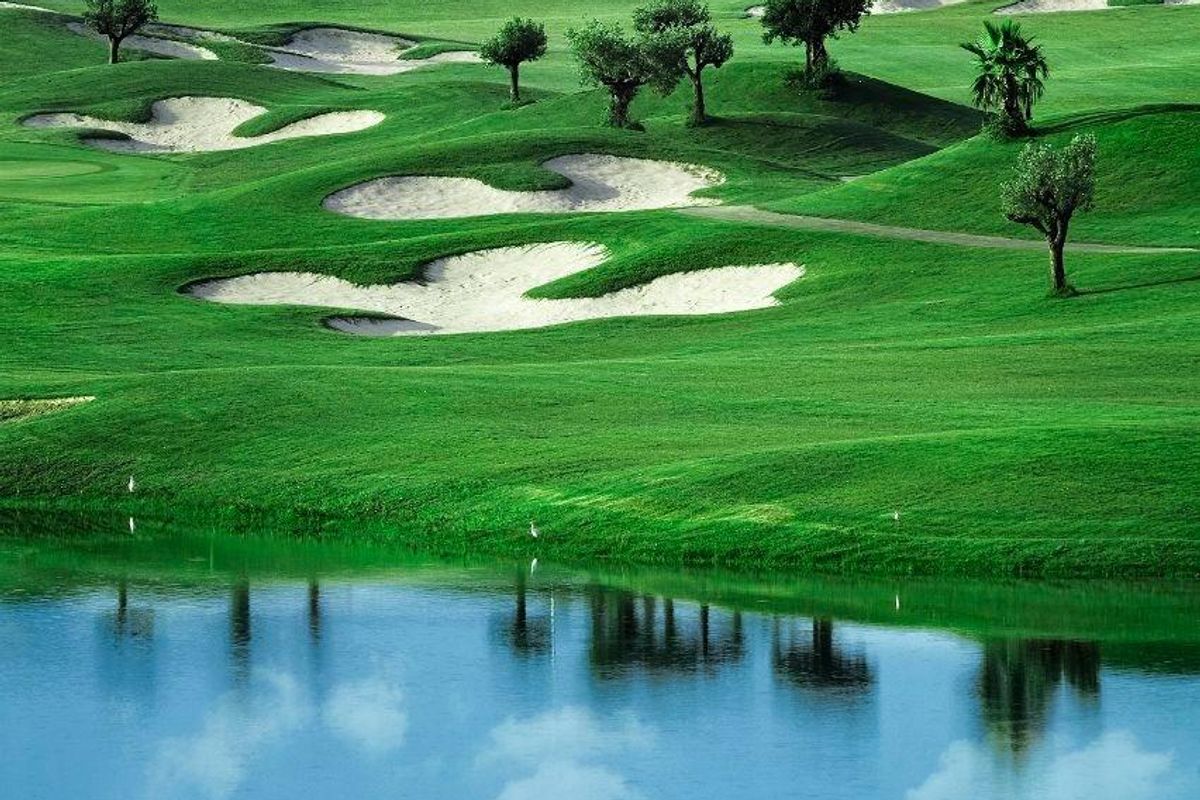 Weelderige groene golfbaan met natuurlijke waterpartijen en zachte heuvels in de Costa Blanca.