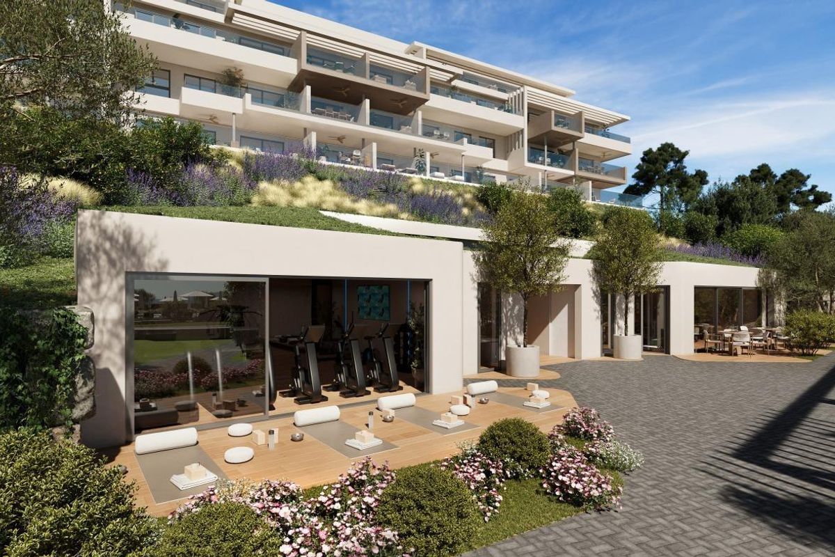 Begane grond van een modern appartementencomplex met aangelegde tuinen in Mijas, Costa del Sol.
