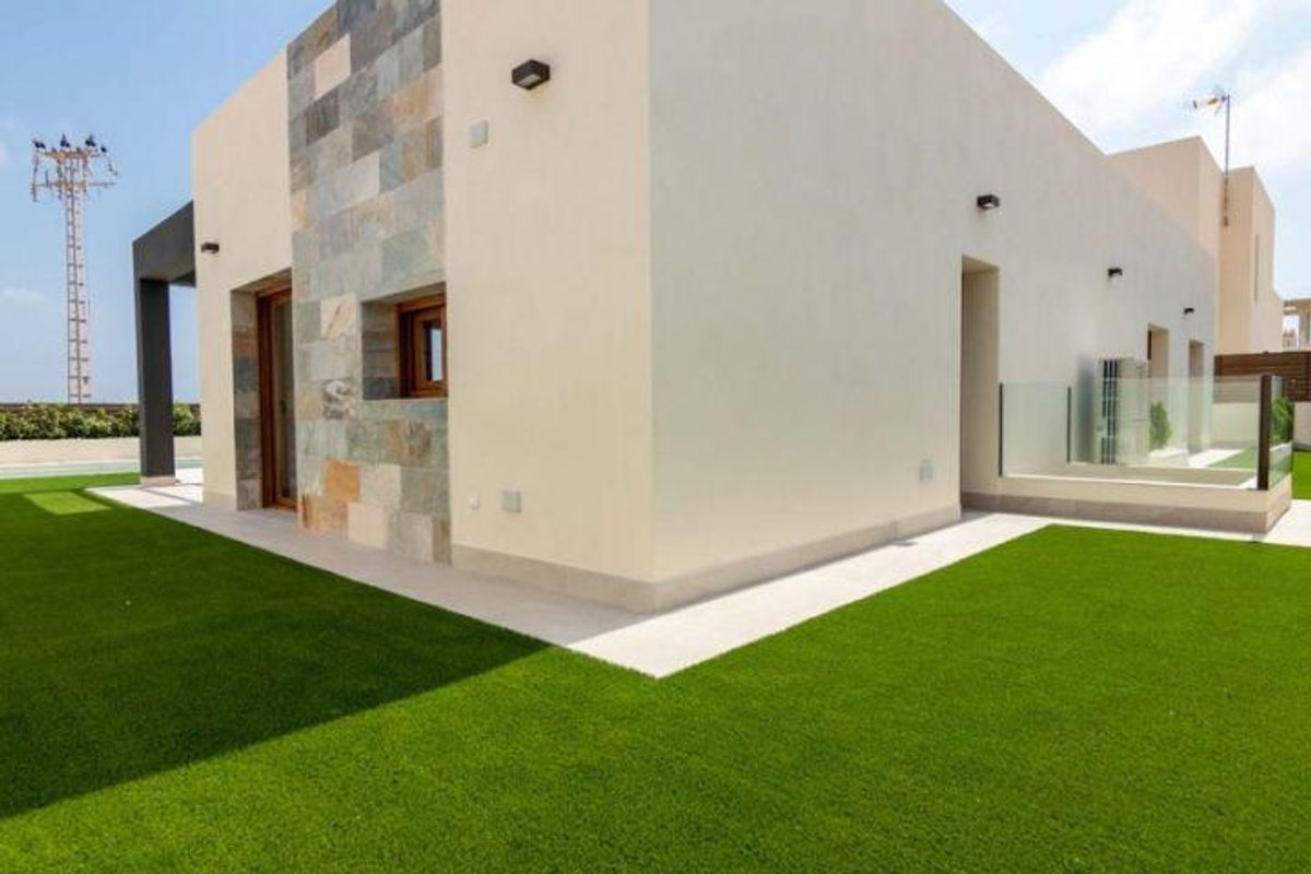 Zijaanzicht van een moderne villa die de strakke architectuur en groen in Torrevieja benadrukt.