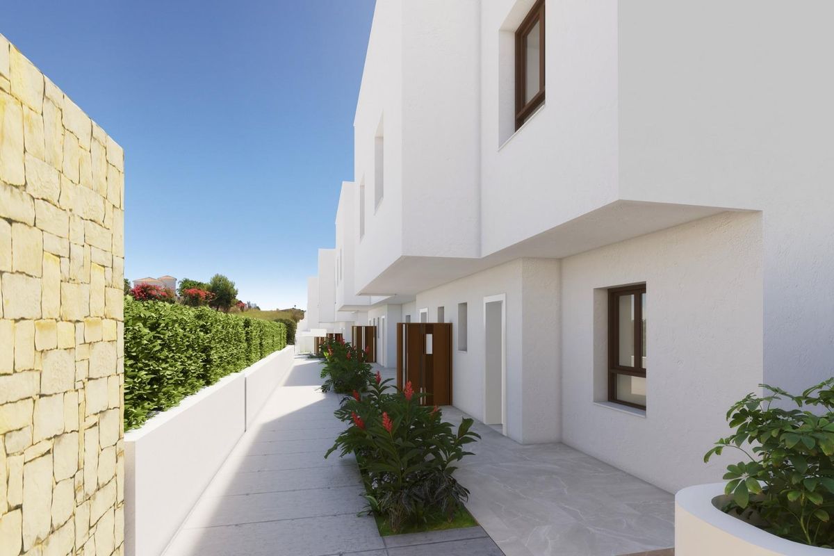 Moderne gevel van een 3-slaapkamer townhouse in Mijas, Costa del Sol, met strakke lijnen en levendig groen.