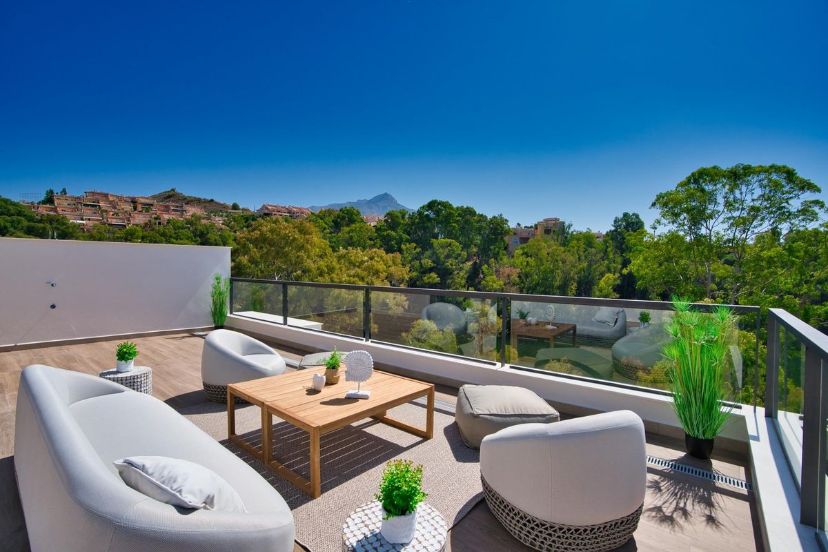 Charmante terras zithoek met bomen en uitzicht op de bergen in penthouse in Marbella, Costa del Sol.