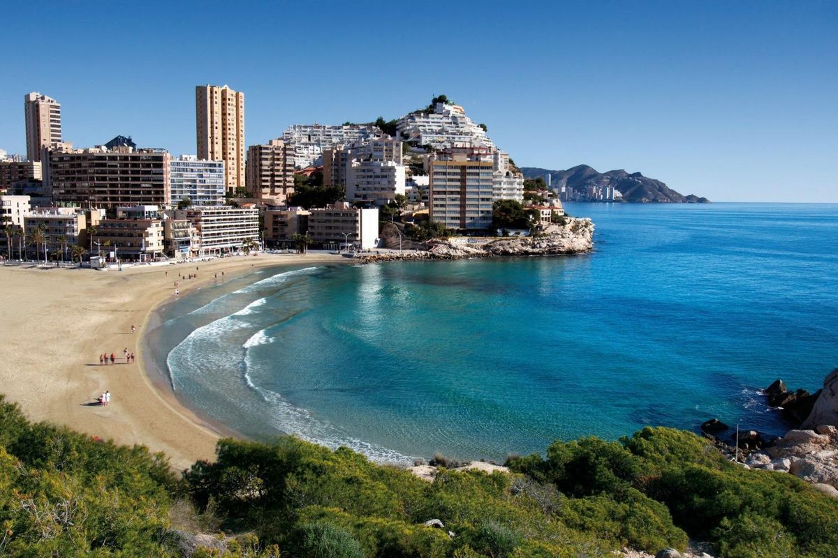 Prachtig strand in Benidorm, zandige kust en helder blauw water onder een zonnige hemel.