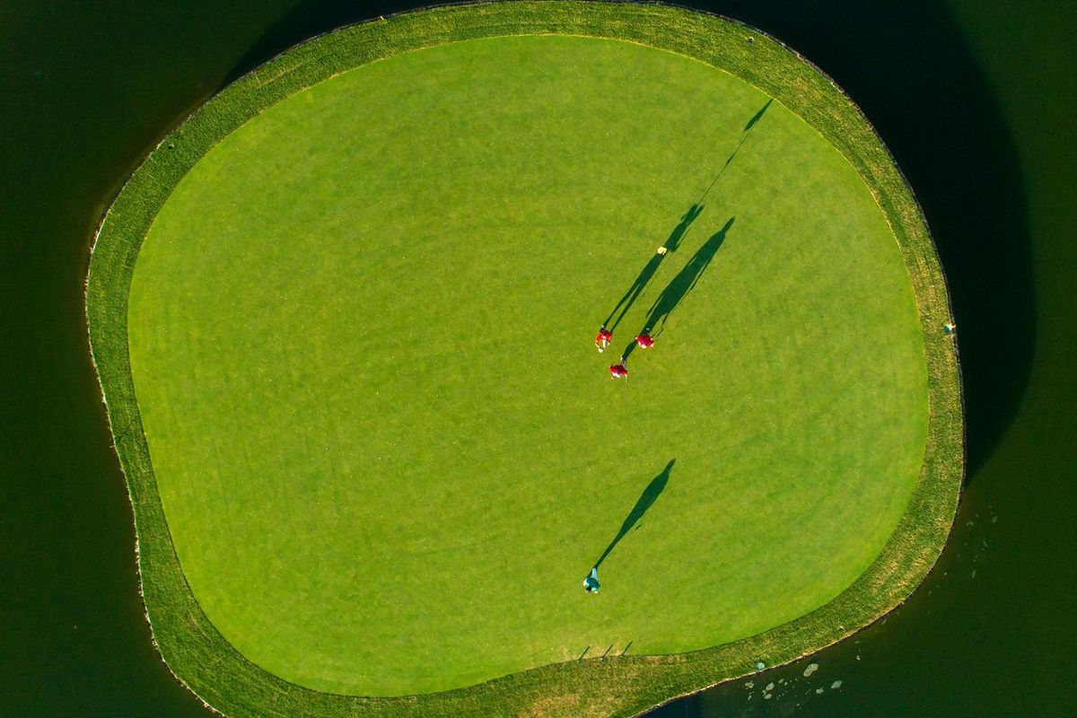 Luchtfoto van golfers die putten op een groene eiland omringd door water in Pilar de La Horadada, Costa Blanca Zuid.