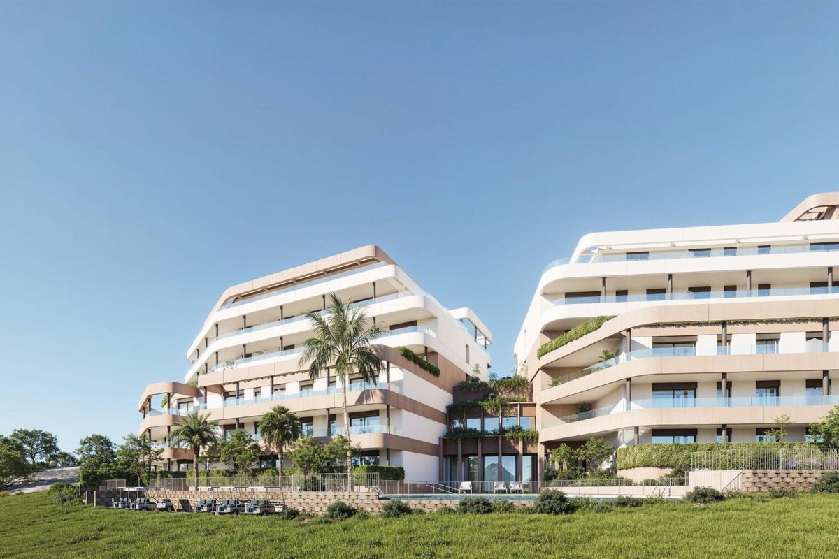 Uitzicht op het moderne appartementencomplex in Estepona met aangelegde tuinen en palmbomen op de voorgrond.