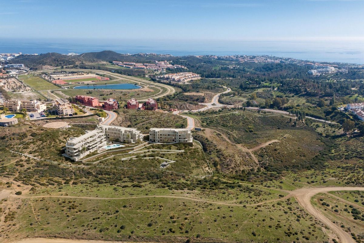 Luchtfoto van een modern complex in Mijas, die het omliggende landschap en de nabijheid van de kust toont.