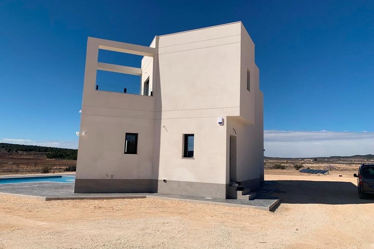 Achteraanzicht dat de structuur van de villa en de ruime buitenruimte in Pinoso, Costa Blanca toont.