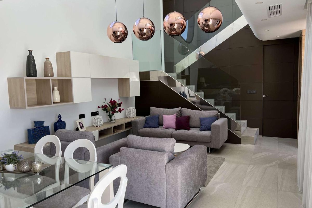 Chique leefruimte met open indeling, grijze banken en decoratieve details in een villa in Rojales.