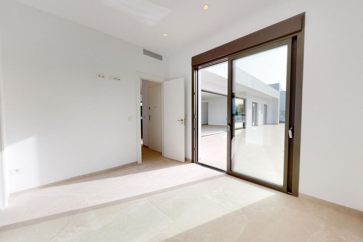 Gezellige slaapkamer met schuifdeuren naar een patio in de villa in Los Alcazares.