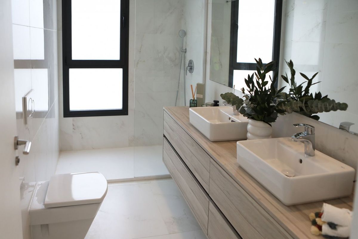 Elegant badkamer met dubbele wastafels en moderne armaturen in een appartement in Benidorm. Ideaal voor een gezin met 3 slaapkamers.