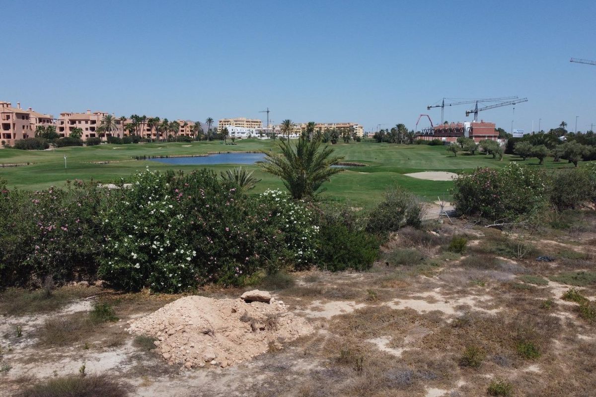 View of golf course with apartments in the background, from plot for development in Los Alcazares, Costa Calida, Spain.