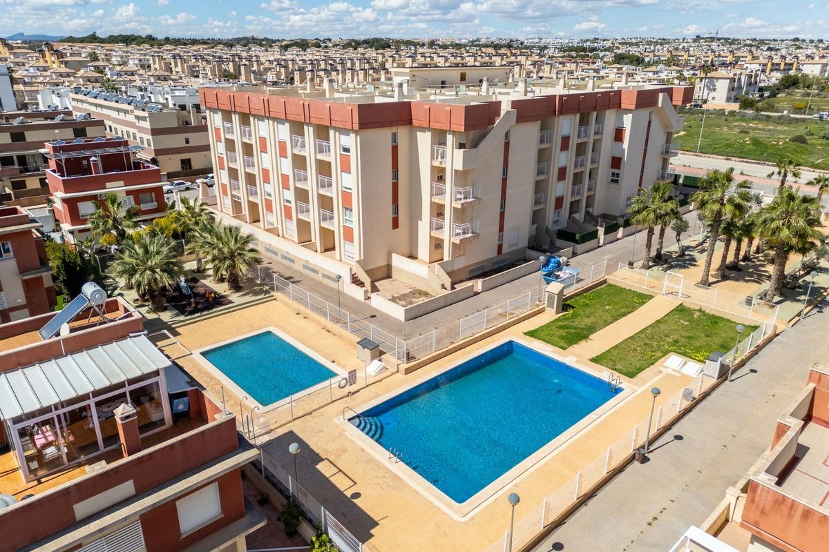 Buitenzicht op een modern appartementencomplex in Orihuela Costa met een zwembad.