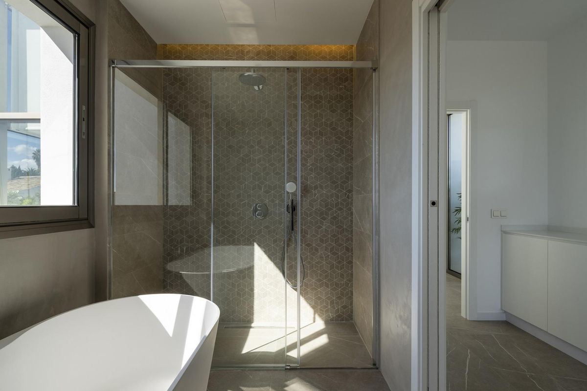 Moderne bad- en douche-indeling in een stijlvolle badkamer van een 4-slaapkamer villa in Mijas, Costa del Sol, met natuurlijk licht.
