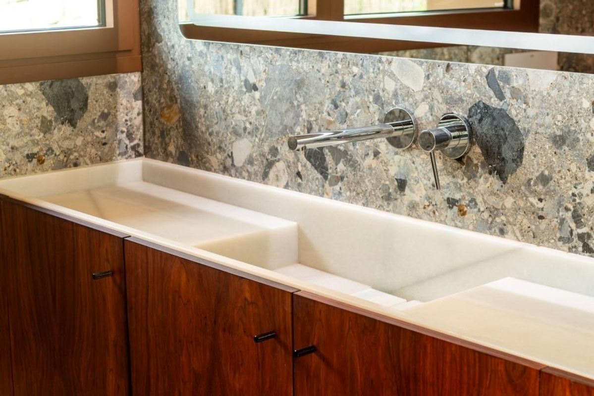 Strakke wastafel met moderne armaturen, die elegantie toevoegt aan het ontwerp van de villa in Calpe, Costa Blanca Noord.