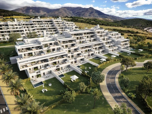 Luchtfoto van modern appartementencomplex in Casares, met weelderige tuinen en een prachtig berglandschap.