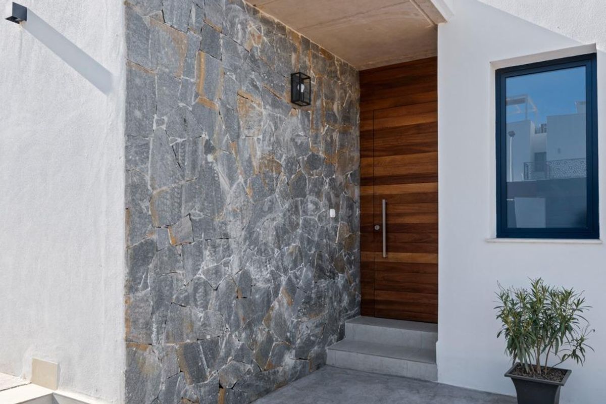 Stijlvolle ingang van de villa met steen- en houtdetails in Cartagena, Costa Calida, Spanje.