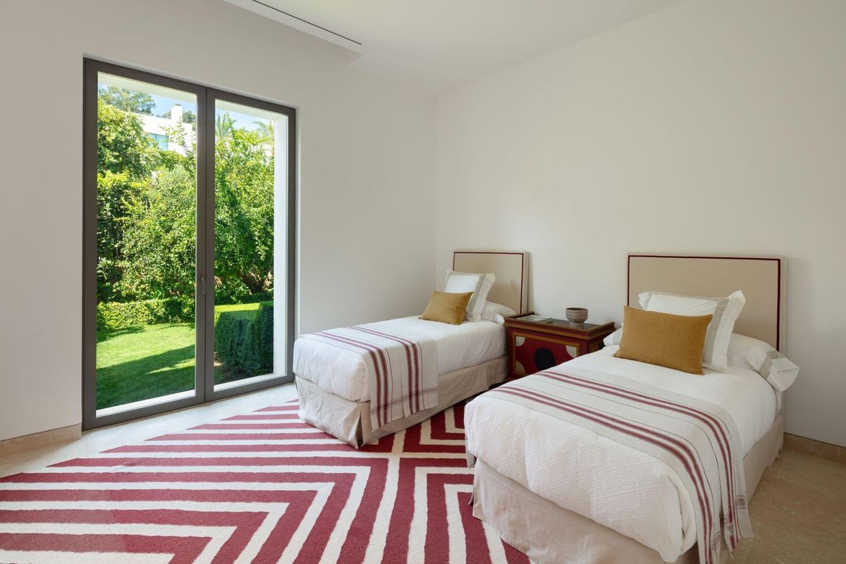 Comfortabele tweepersoons slaapkamer met uitzicht op de tuin in een luxe villa met zes slaapkamers in Casares, Spanje.